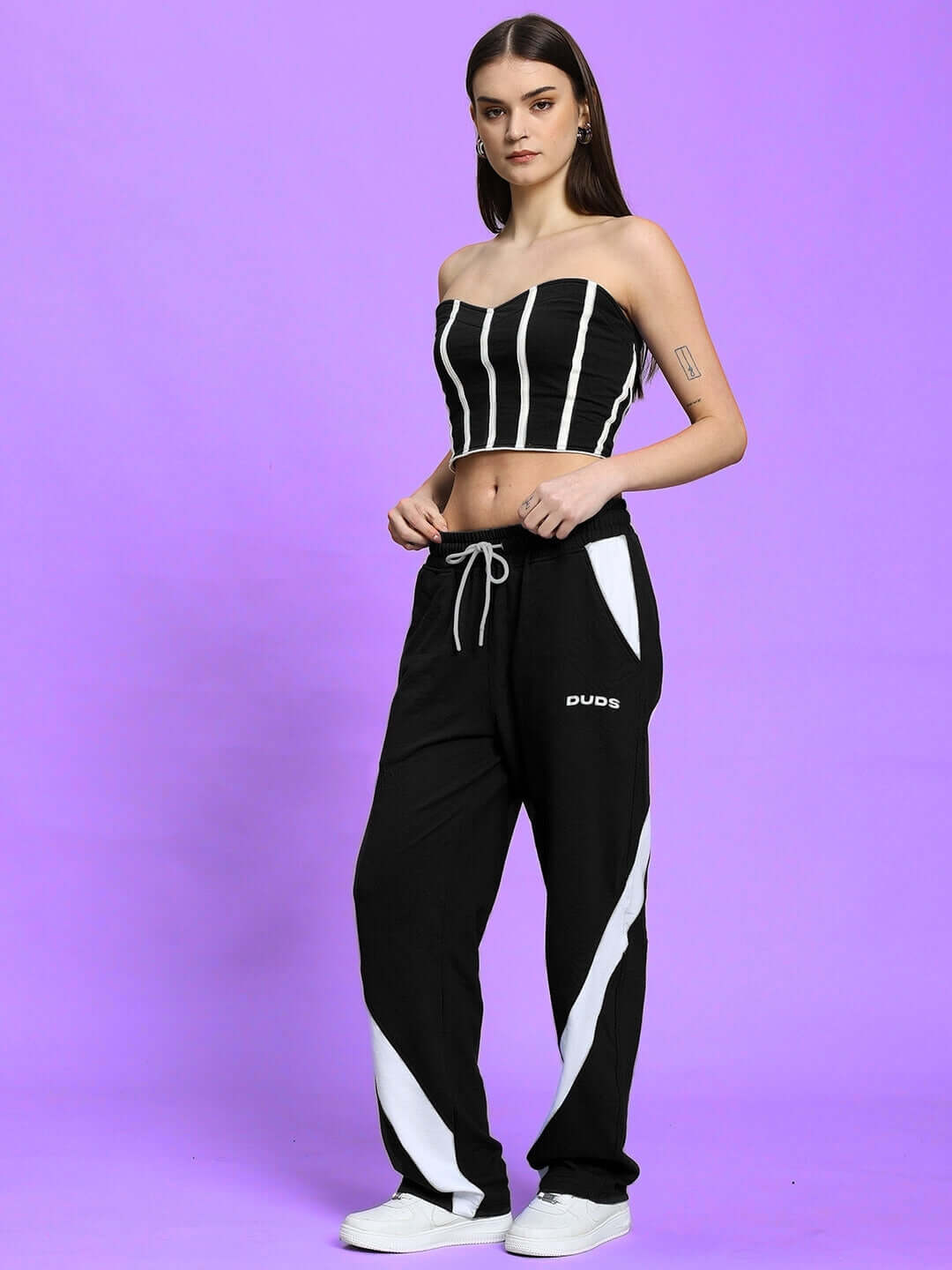 Model wearing WOMEN'S LIVIANA COOL CO-ORD SET BLACK by WEAR DUDS, featuring chic streetwear style with striped top and matching pants.