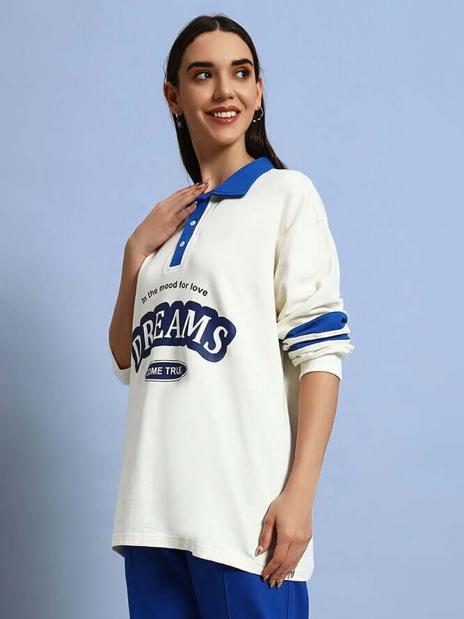 Woman wearing oversized off white-royal blue sweatshirt with 'LOVE DREAMS' print, made of premium cotton French terry, 97% cotton.