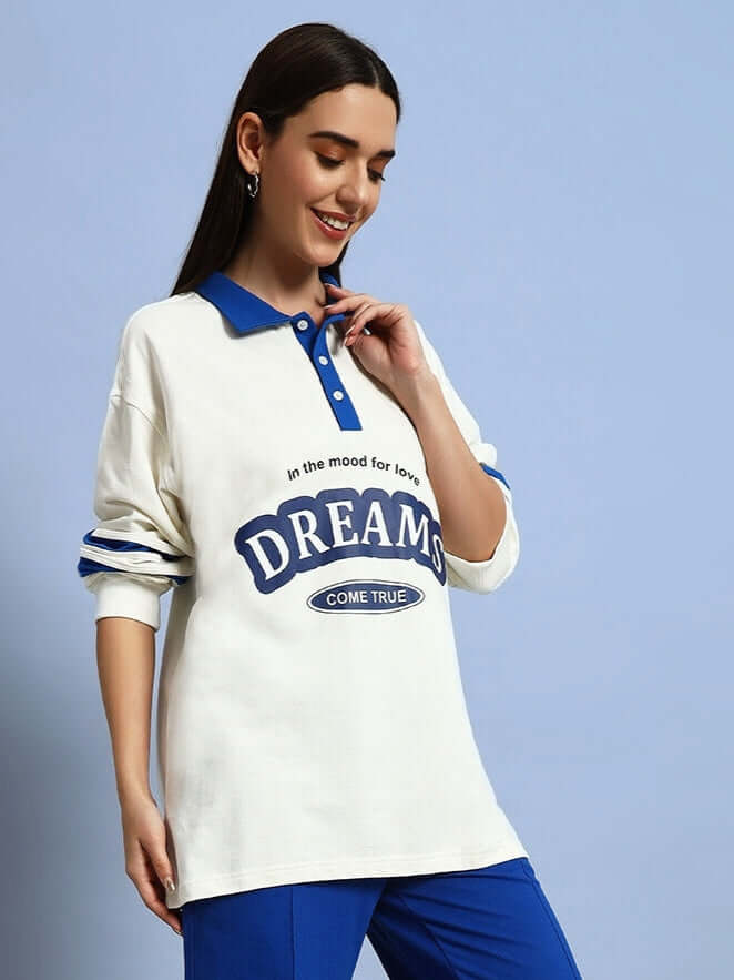 Woman wearing oversized off-white and royal blue Dreams sweatshirt, featuring premium cotton fabric, stylish design, and comfortable fit.