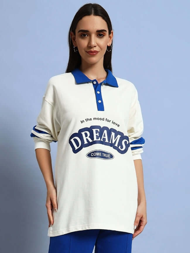 Woman wearing oversized off-white and royal blue sweatshirt with 'Dreams Come True' print, made of premium cotton blend fabric.