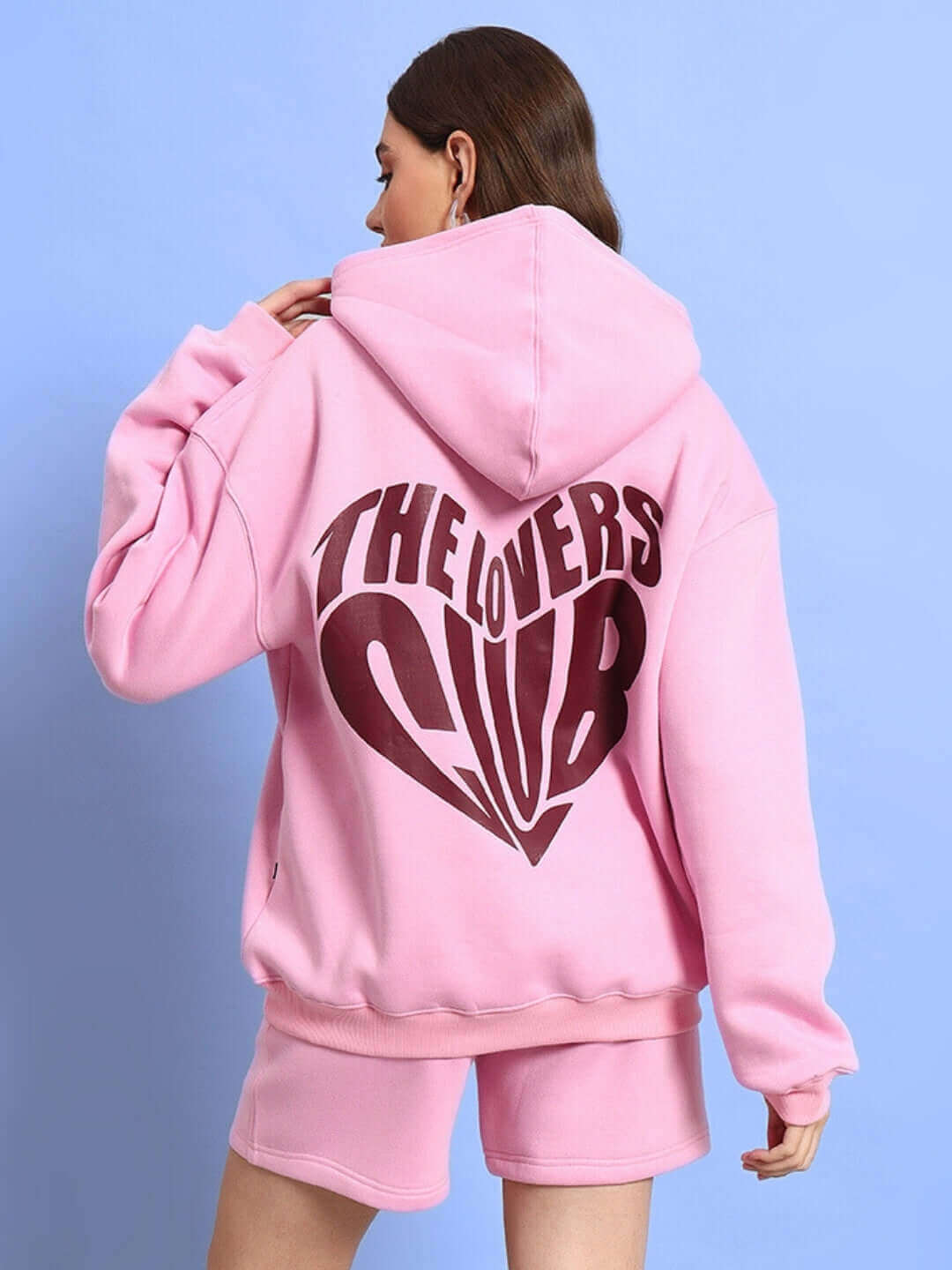 Woman wearing WOMEN LOVERS CLUB FLEECE HOODIE PINK, showcasing back design, perfect for casual streetwear and cozy style.