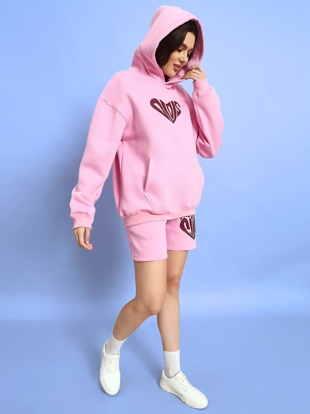 Woman wearing WOMEN LOVERS CLUB FLEECE SHORTS PINK with matching hoodie, showcasing a casual and youthful street style.