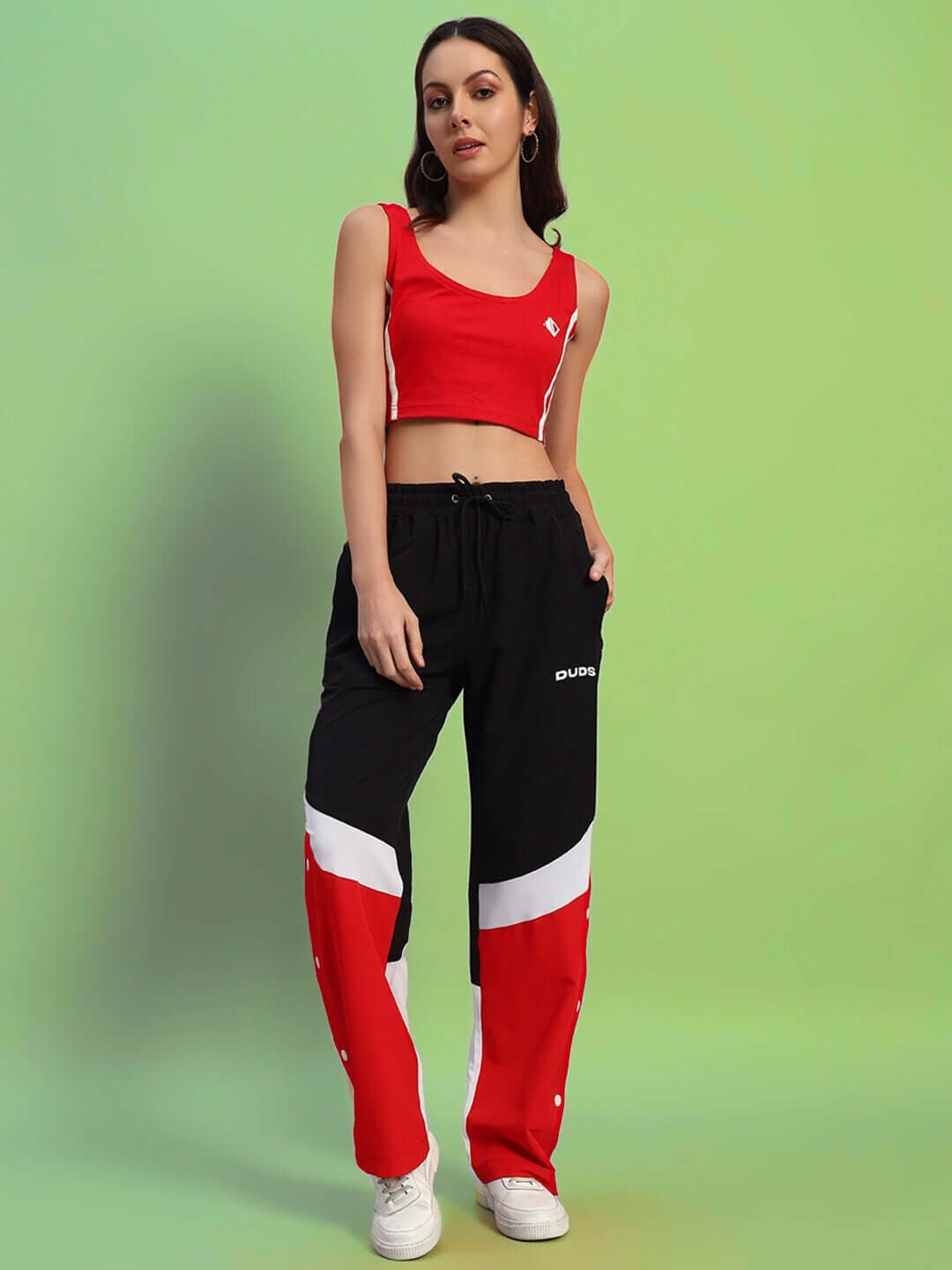 Model wearing women's Marco relaxed fit cargo pants in black-red, paired with a red crop top. Available in custom size options.