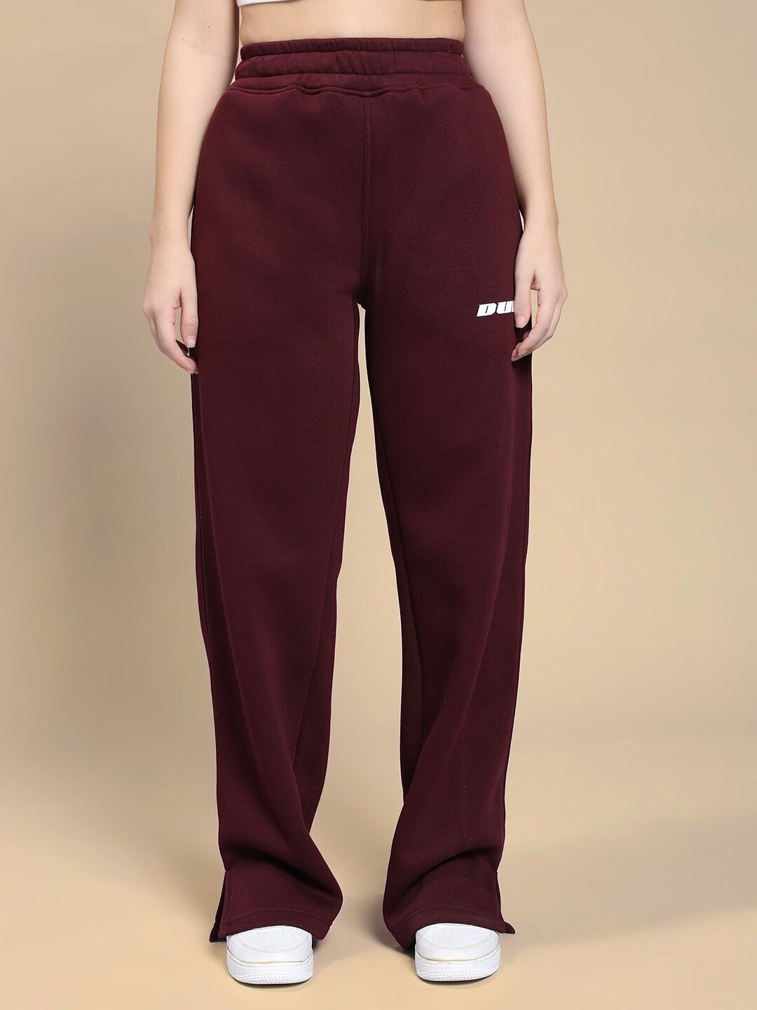 Model wearing WOMEN SKODA FLEECE CO-ORD SET MAROON with white sneakers, showcasing trendy and comfortable loungewear fashion.
