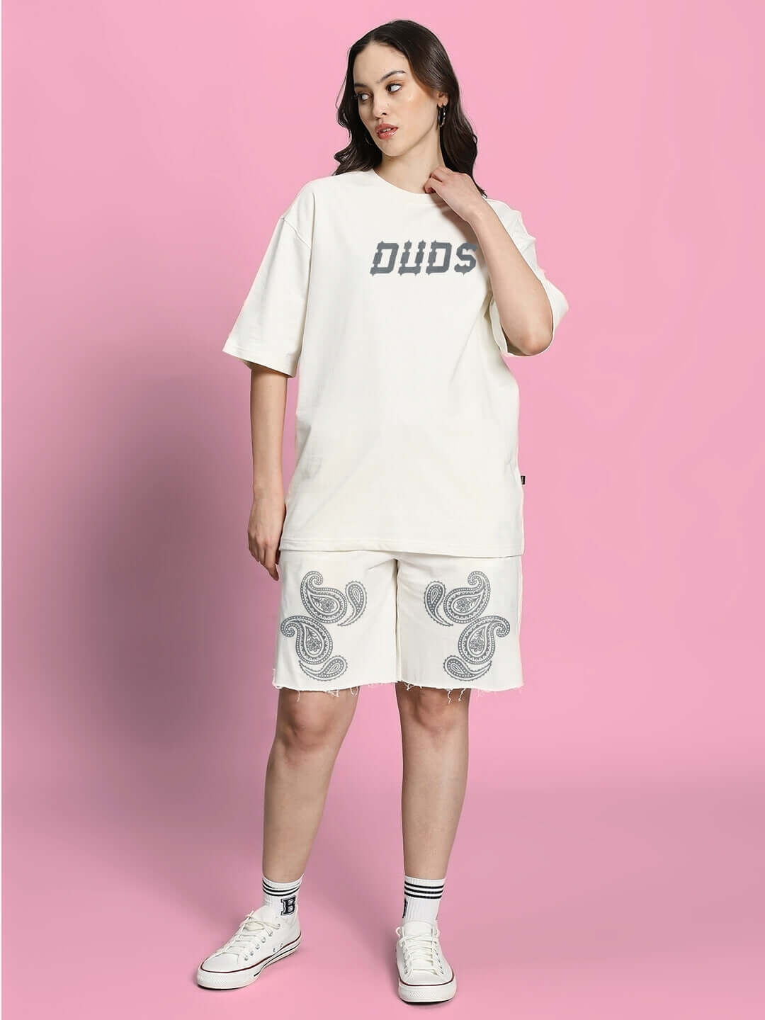 Woman wearing the WOMEN'S MESSI PAISLEY PRINT CO-ORD SET OFF WHITE with paisley print on a pink background.