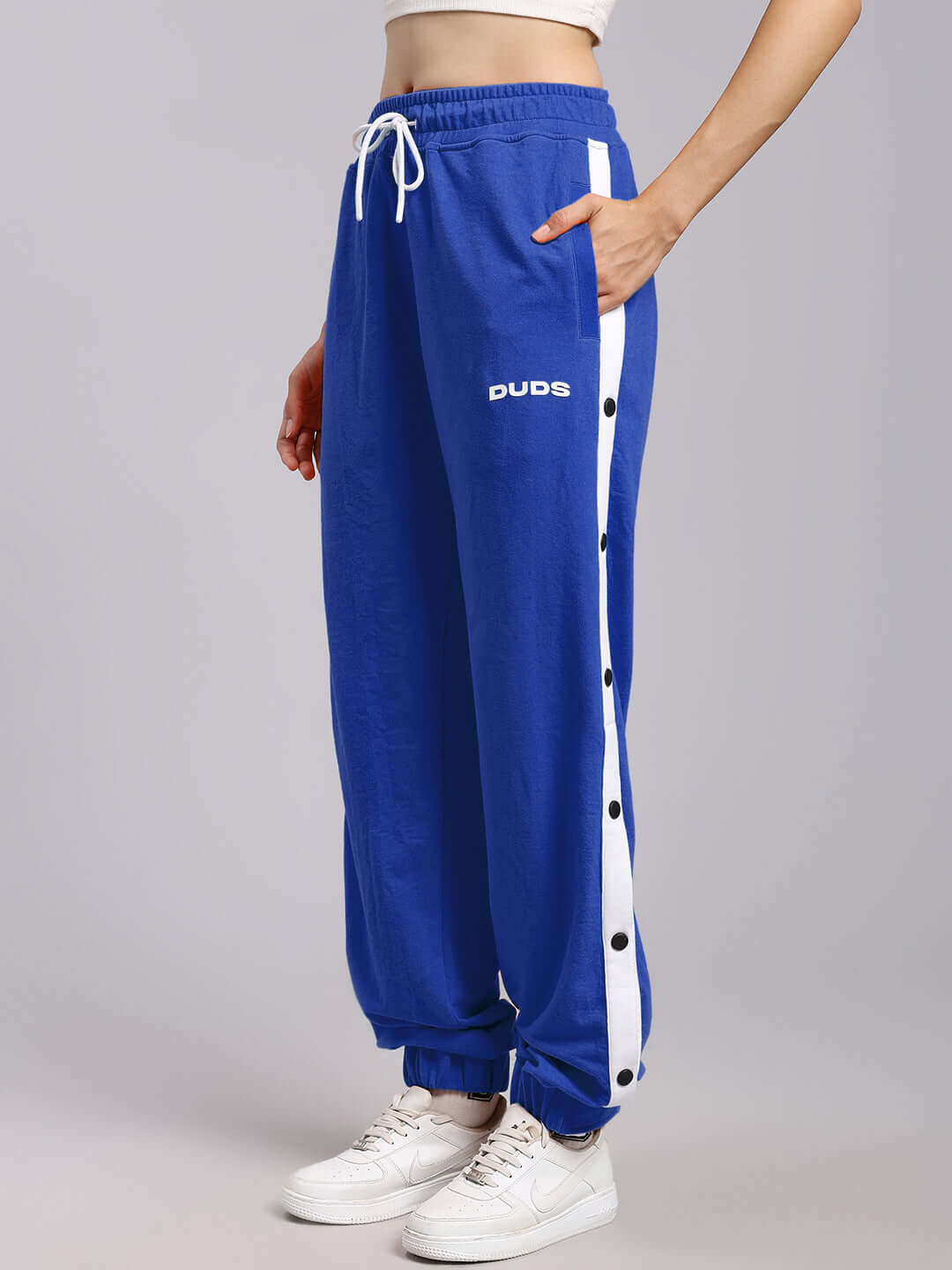 Woman wearing WOMENS MILLER RELAXED FIT JOGGERS BLUE, showcasing side view and button details.