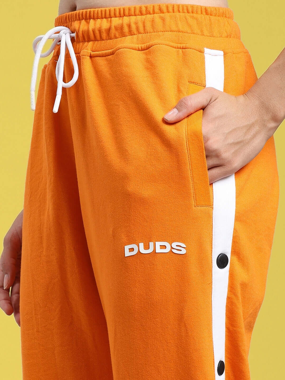 Close-up of WOMENS MILLER RELAXED FIT JOGGERS ORANGE, featuring soft fabric and stylish design with side stripe detail.