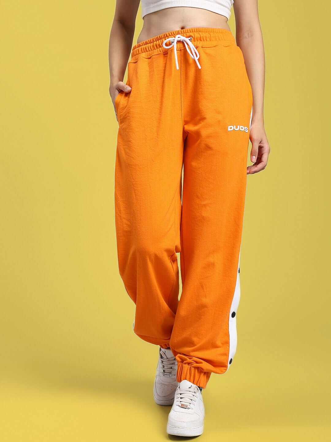 WOMENS MILLER RELAXED FIT JOGGERS ORANGE worn by a model, showcasing the vibrant color and comfortable fit for casual wear.