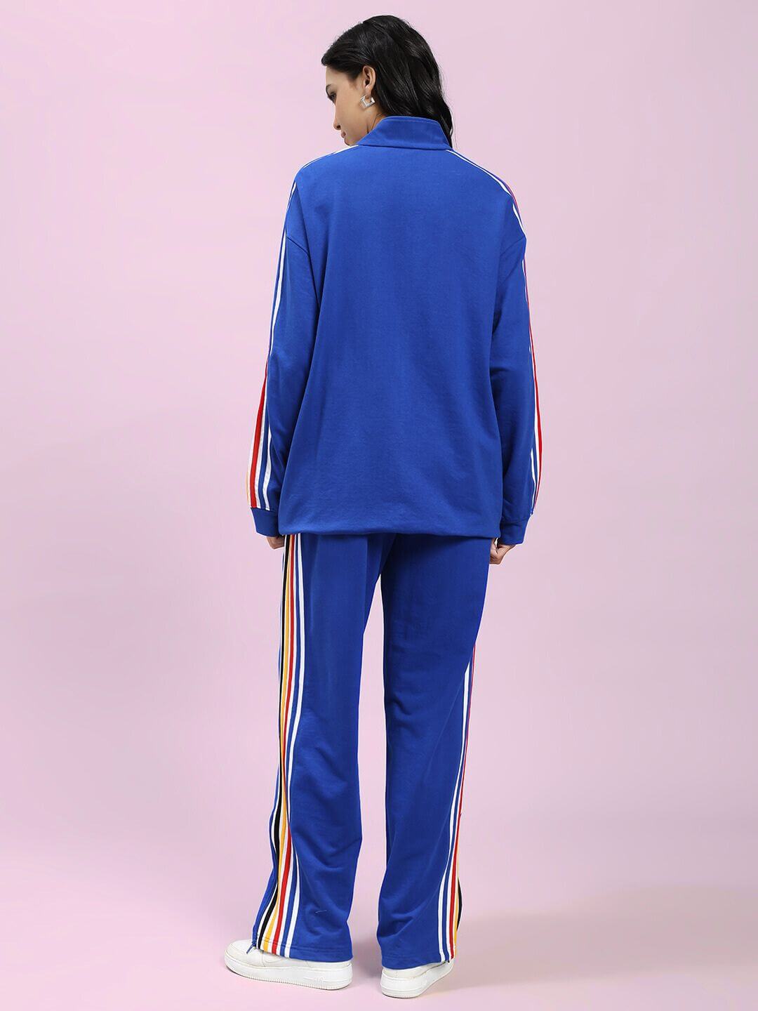 Back view of woman in WOMEN MODERN EDGE MULTI-STRIPE CO-ORD SET ROYAL BLUE with colorful stripes, showcasing sporty streetwear style.