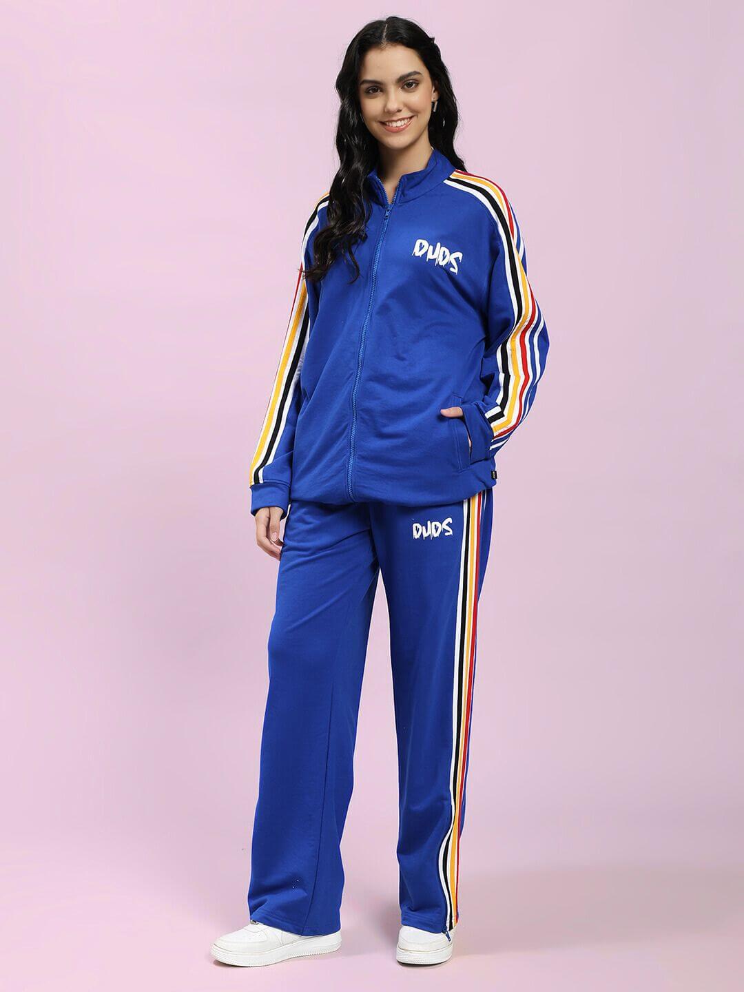 Model wearing WOMEN MODERN EDGE MULTI-STRIPE CO-ORD SET ROYAL BLUE with sporty multicolor stripes on sleeves and pants.