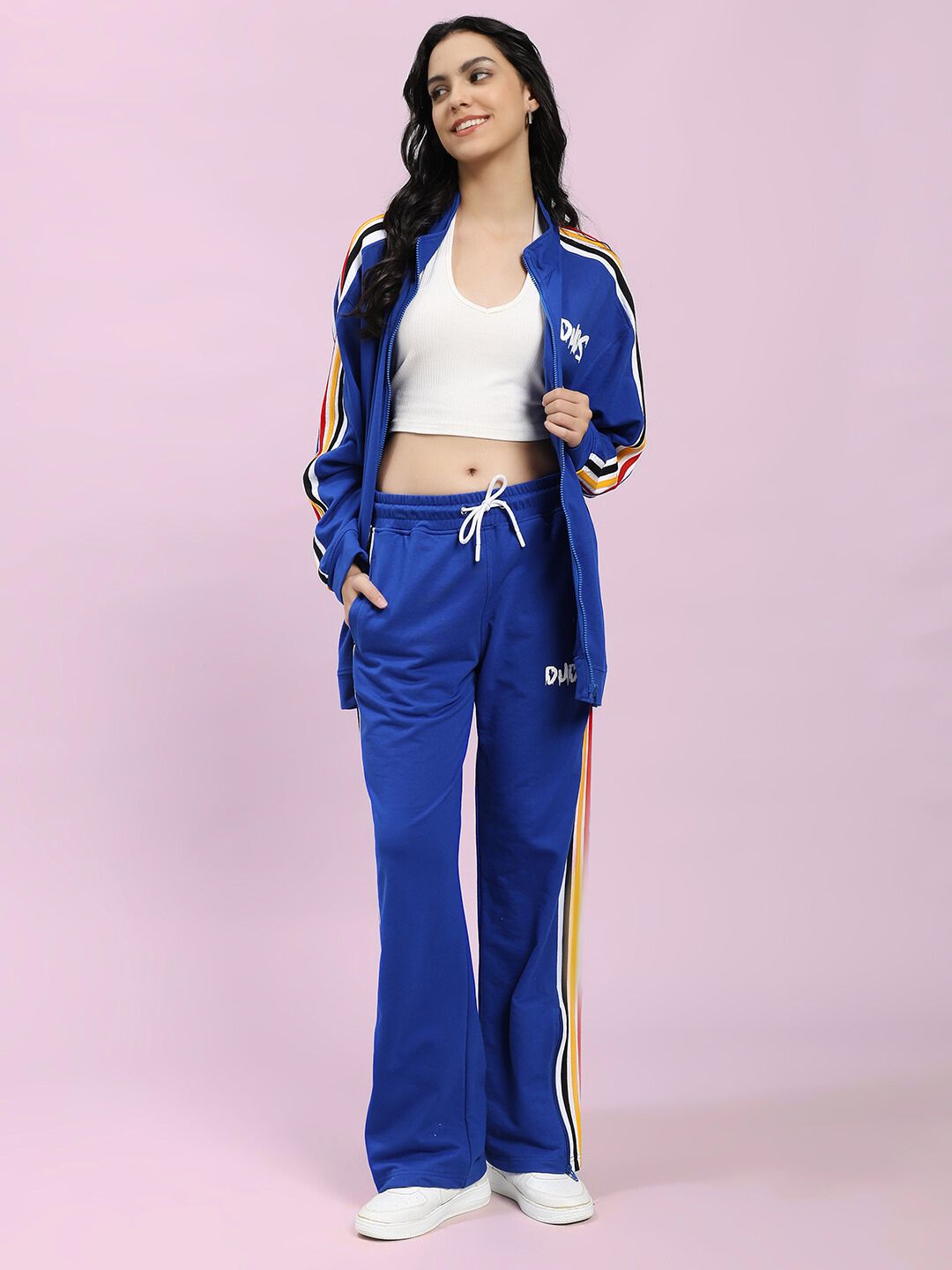 Fashion model wearing the WOMEN'S MODERN EDGE MULTI-STRIPE JOGGER ROYAL BLUE with matching jacket, showcasing a stylish and comfortable outfit.