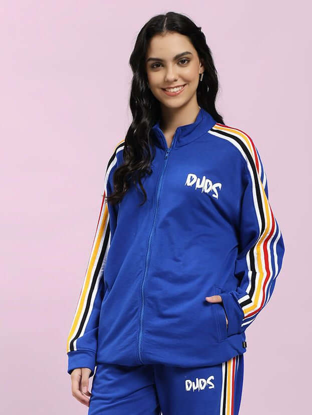 Woman wearing WOMEN MODERN EDGE MULTI-STRIPE JACKET ROYAL BLUE with colorful stripe details, sporty and stylish jacket.