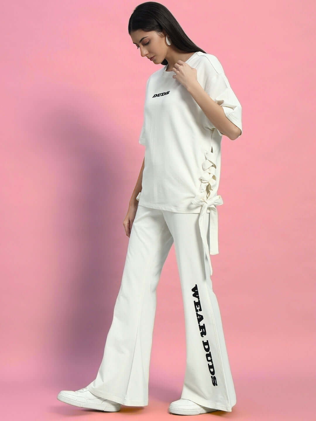 Woman wearing the off-white Women's Moon Night Co-ord Set with relaxed fit joggers and elastic waistband on a pink background.