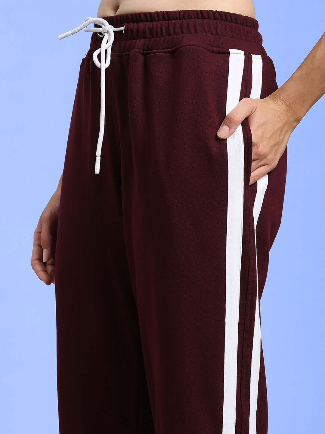 Maroon relaxed fit joggers for women with white side stripes, featuring a drawstring waist. Ideal for custom fit and comfort.