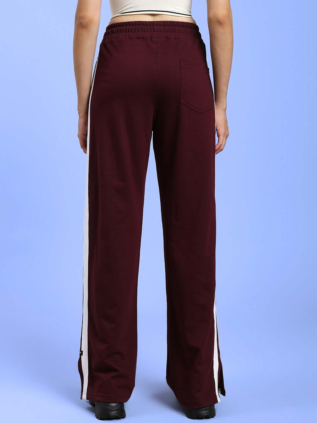 Back view of Women's Moscow Relaxed Fit Joggers in Maroon color, featuring an elastic waistband and full-length style, worn by a model.