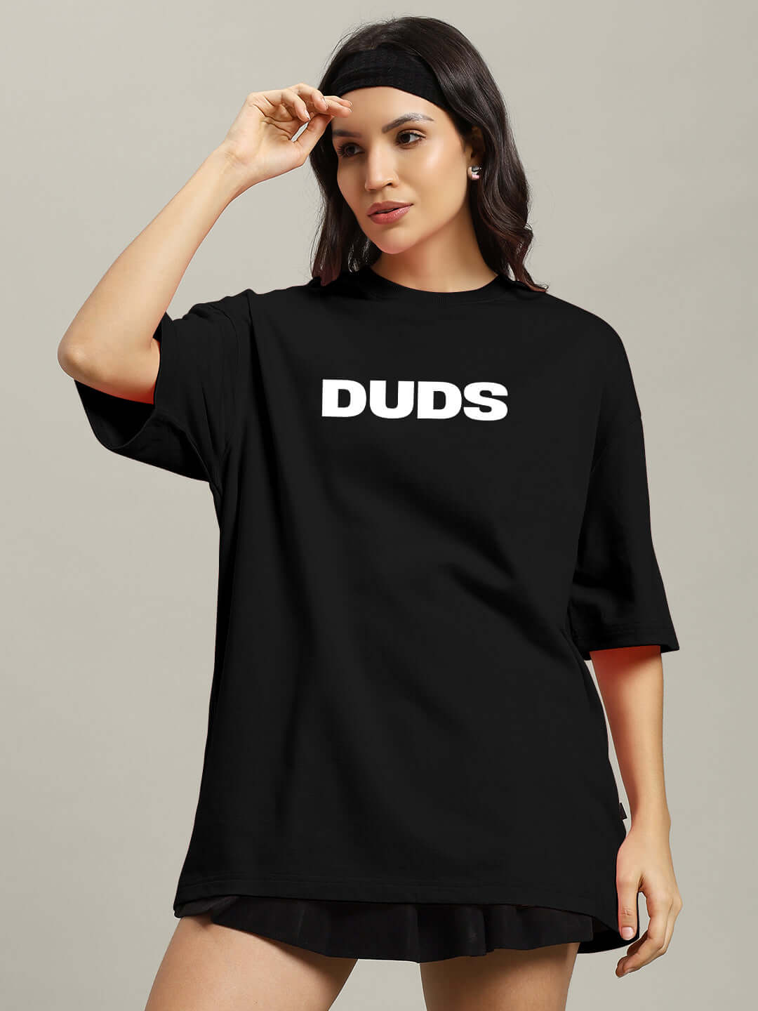 Woman wearing black oversized T-shirt made from premium cotton with "DUDS" text, perfect for casual wear.