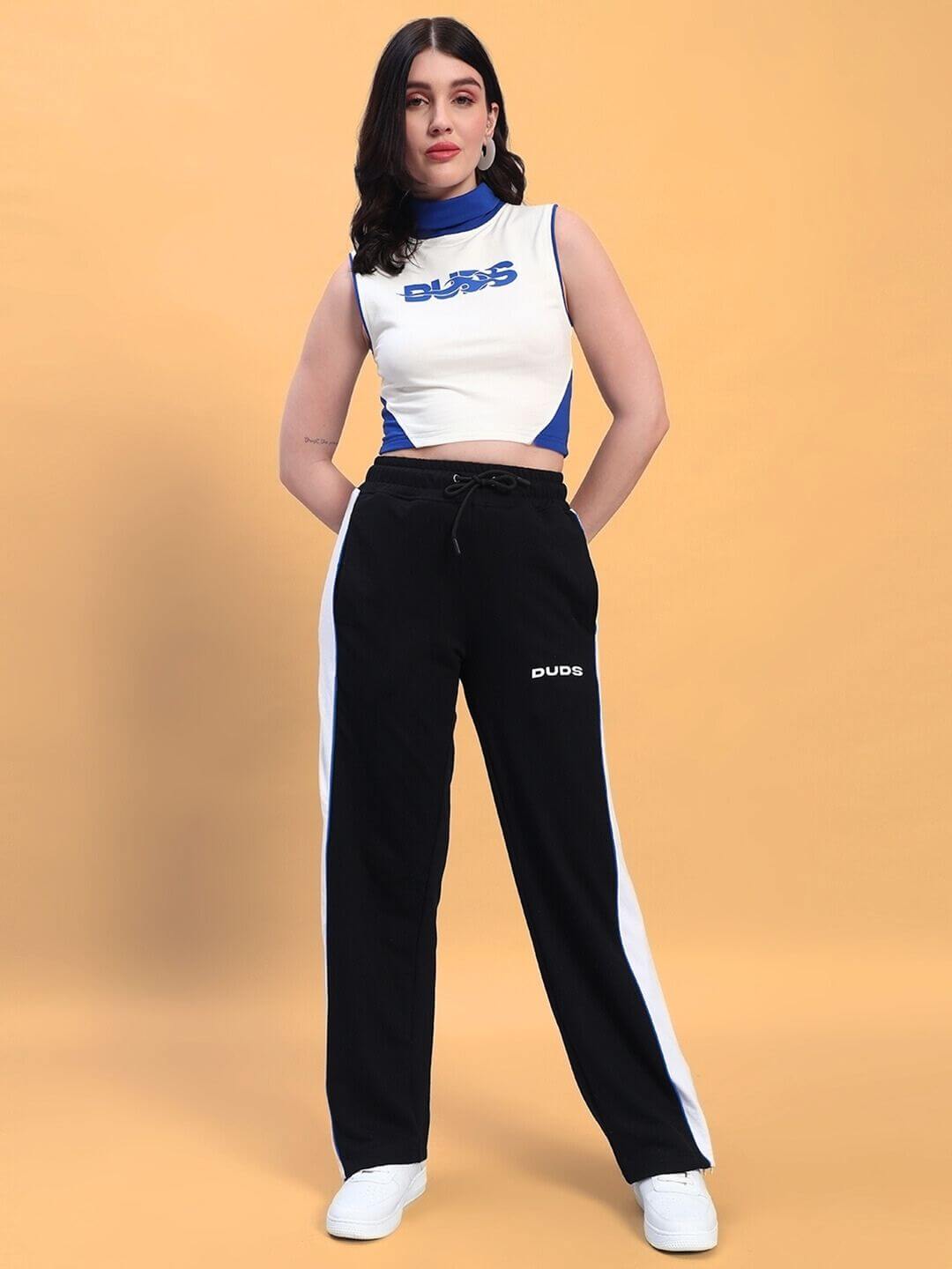 Model wearing WOMEN'S MYSKY CO-ORD SET WHITE ROYAL BLUE with sporty white and royal blue top and black track pants, standing confidently.