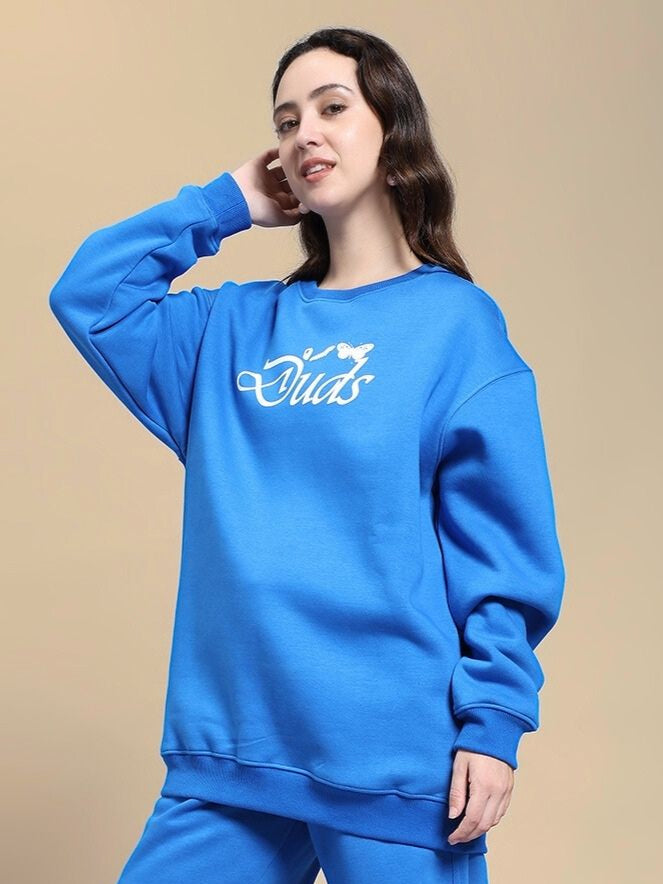 Woman wearing WOMEN NATURE LINK FLEECE SWEATSHIRT ROYAL BLUE, standing indoors.