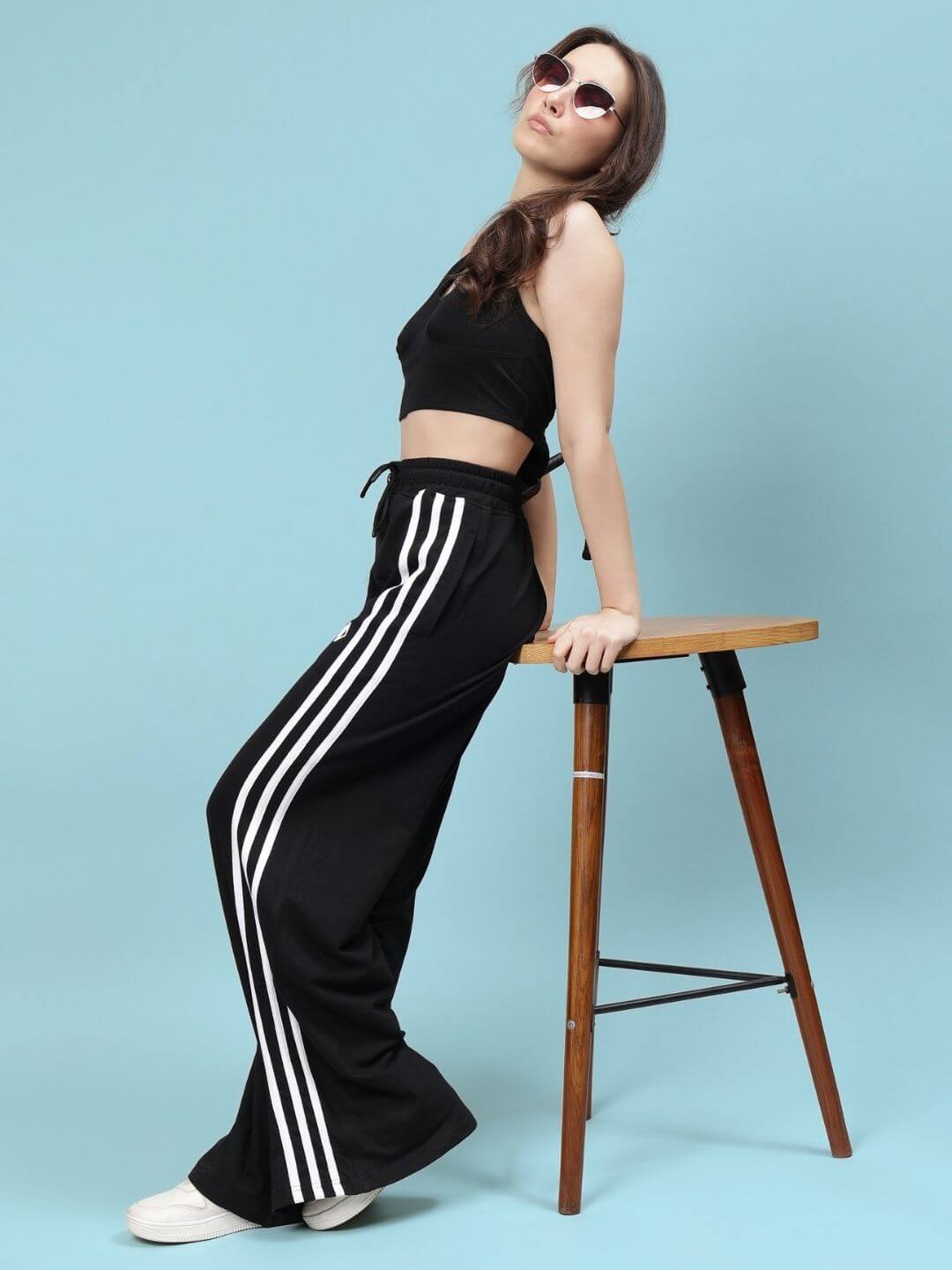 Model wearing WOMEN'S NEER CO-ORD SET - BLACK, featuring stripes, showcasing stylish comfort and versatility against a blue backdrop.