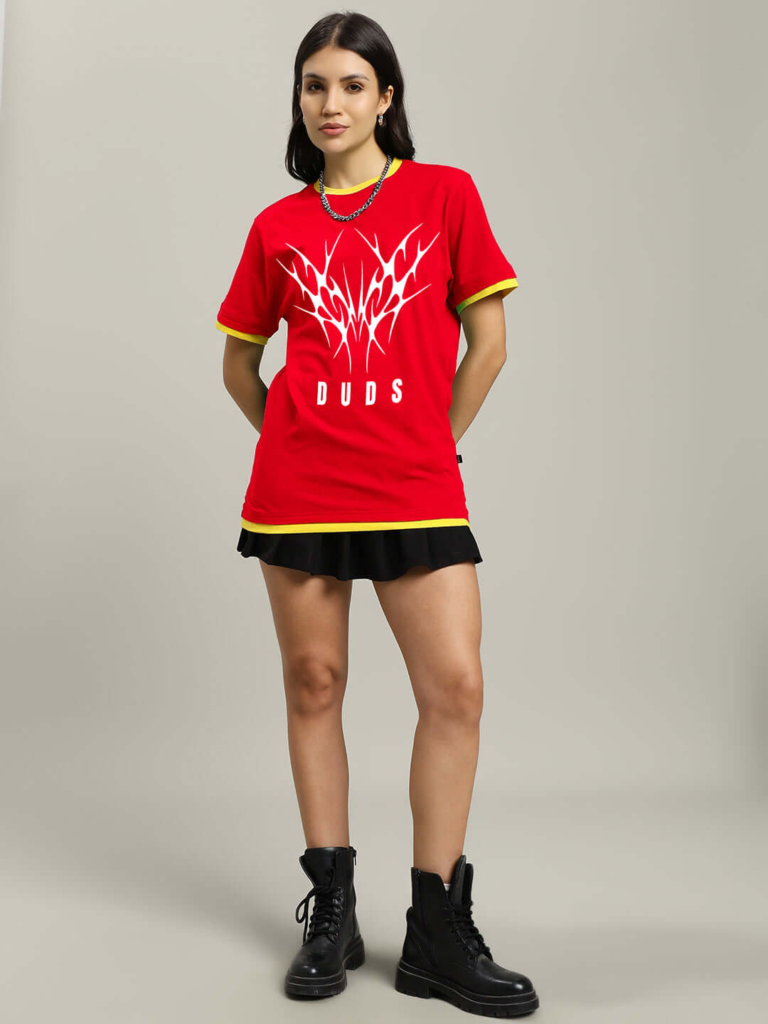 Woman wearing a red NORIBA regular fit t-shirt, 100% cotton, styled with black skirt and boots, showcasing women's casual fashion.