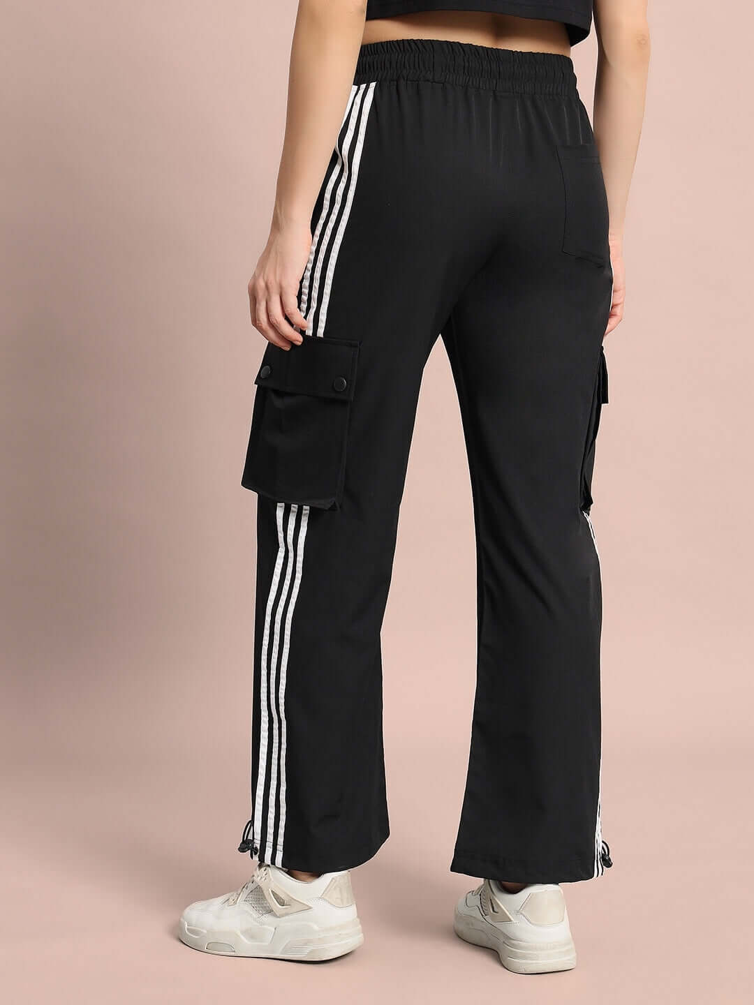 Back view of women's Nova Relaxed Fit Cargo Pants in black with white stripe detail, highlighting pockets and relaxed leg fit.