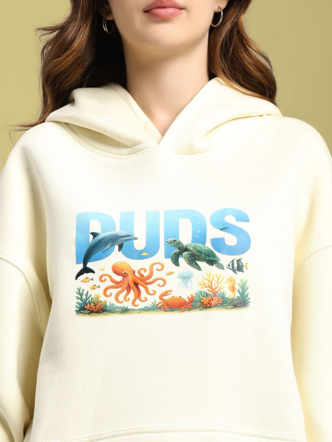 Woman wearing WOMEN'S OCEAN BUDDIES OVERSIZED FLEECE HOODIE OFF-WHITE with marine life print