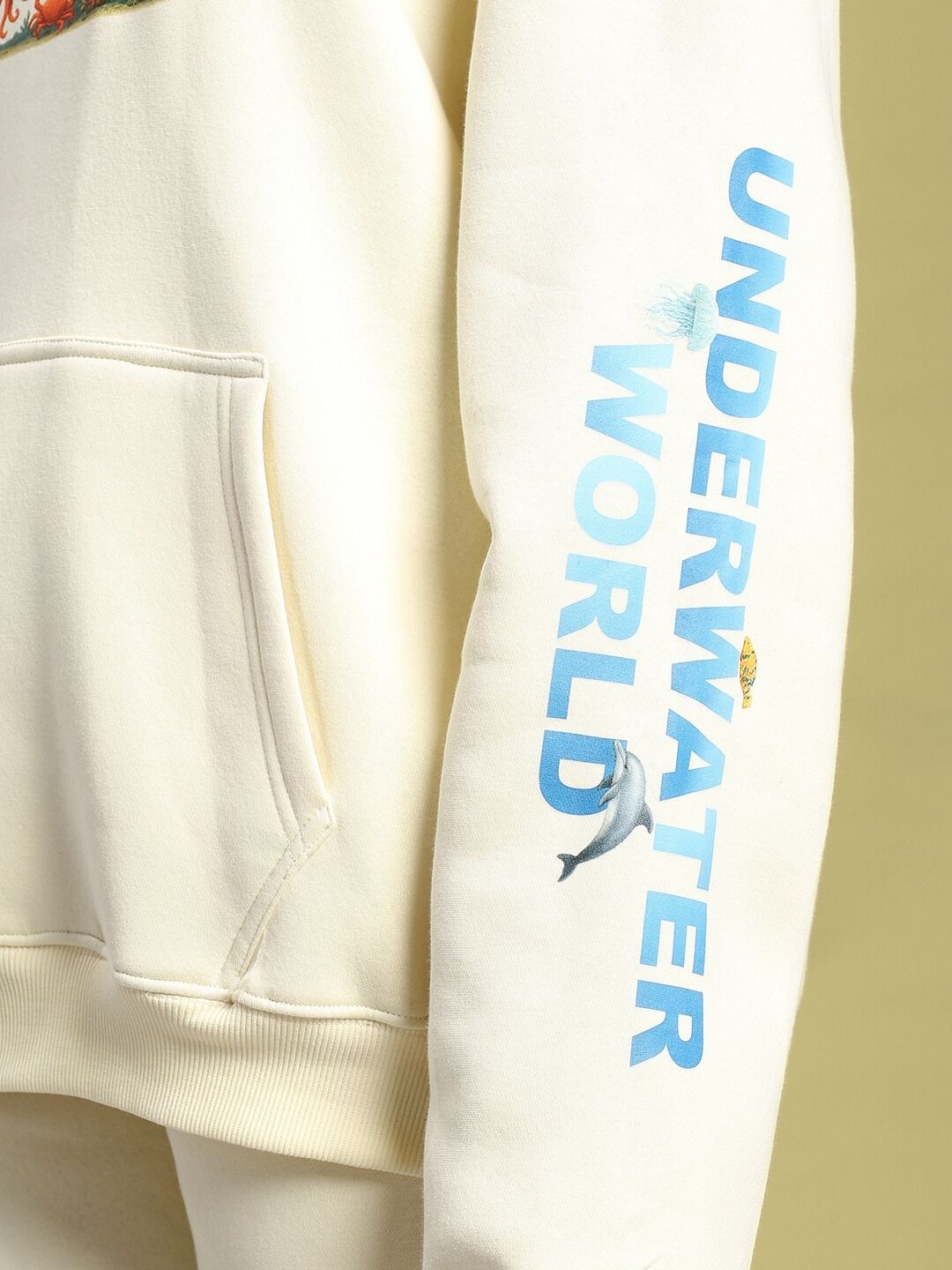 Close-up of sleeve detail on WOMEN'S OCEAN BUDDIES OVERSIZED FLEECE HOODIE OFF-WHITE with underwater theme.