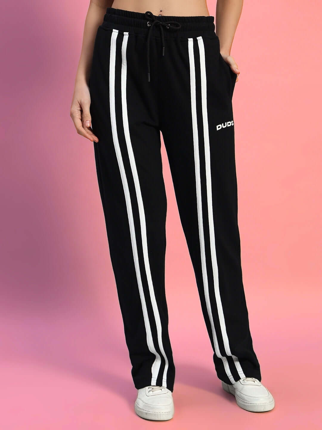 WOMEN'S OUTLOOK CO-ORD SET BLACK WITH WHITE STRIPE pants detail against a pink background showcasing sporty style and comfort.