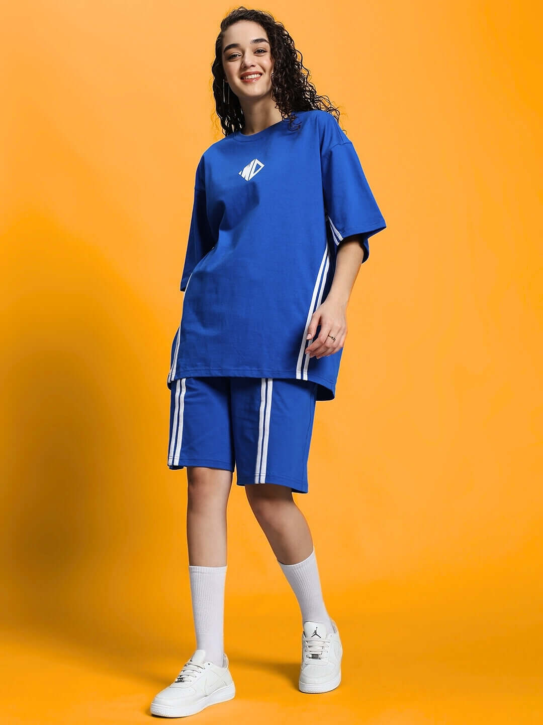 Woman wearing WOMEN'S OUTLOOK SUMMER CO-ORD SHORTS SET ROYAL BLUE, featuring breathable fabric and casual style on orange background.