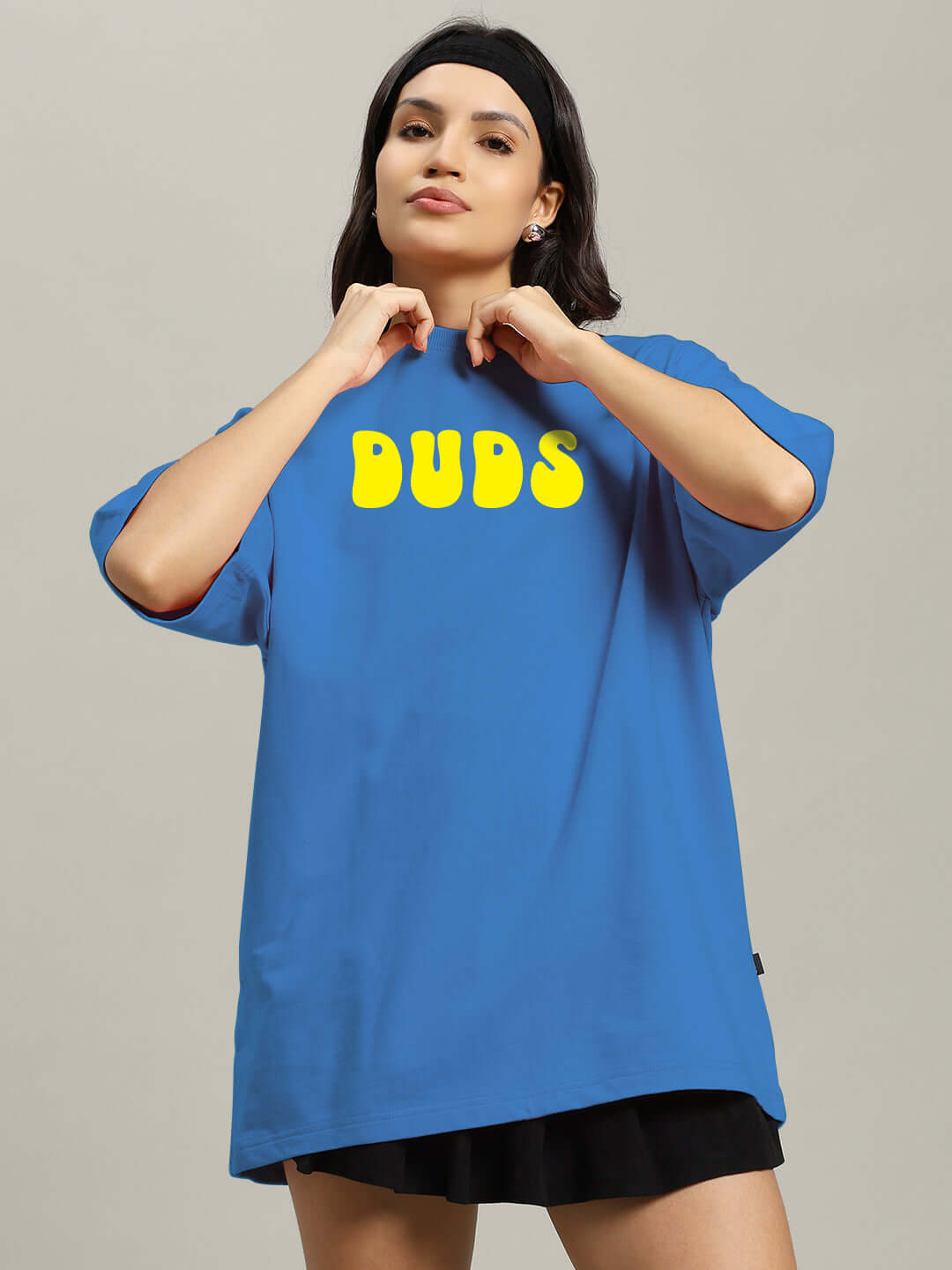 Model wearing oversized blue women's t-shirt with 'DUDS' text, crafted from 97% premium cotton and 3% elastane, ideal for casual wear.