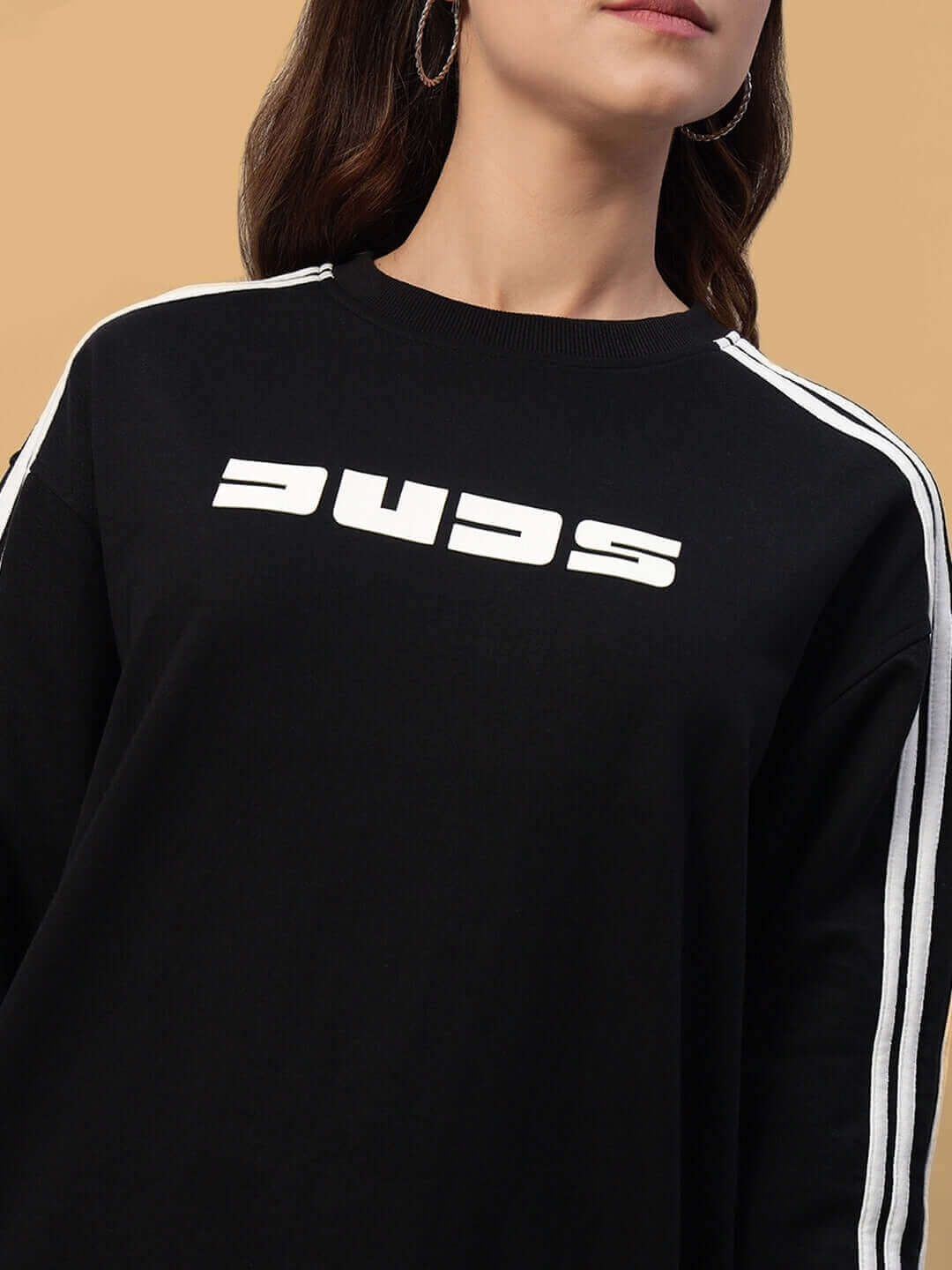 Model wearing black oversized women's parka sweatshirt with white stripes and logo, made of premium cotton French terry lycra.