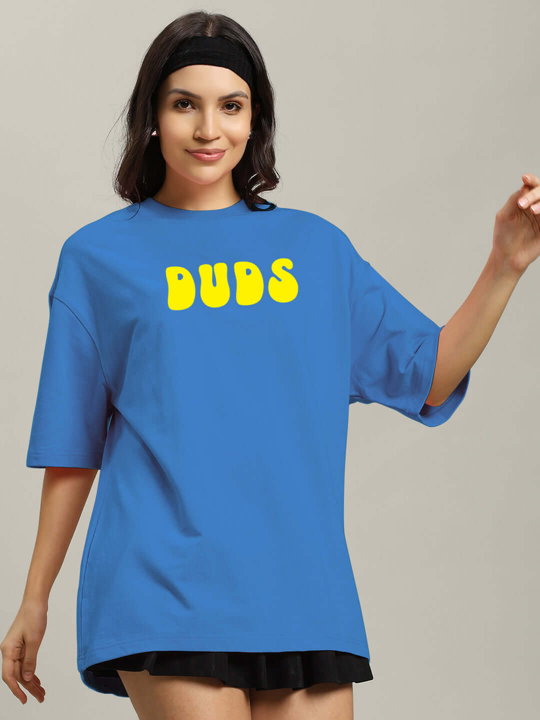 Woman wearing blue oversized 'DUDS' T-shirt, featuring premium cotton fabric for comfort and style.