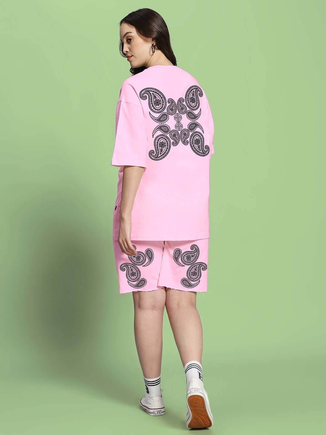 Model wearing Women's Messi Paisley Print Co-Ord Set Pink, featuring oversized paisley design on t-shirt and shorts.