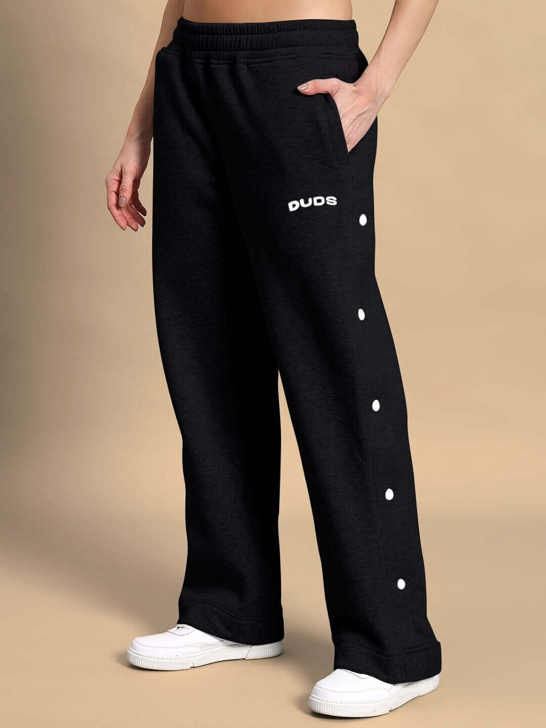 Black fleece pants from WOMEN POLAR COLORBLOCK CO-ORD BLACK PEACH, featuring side buttons and cozy design for modern streetwear.