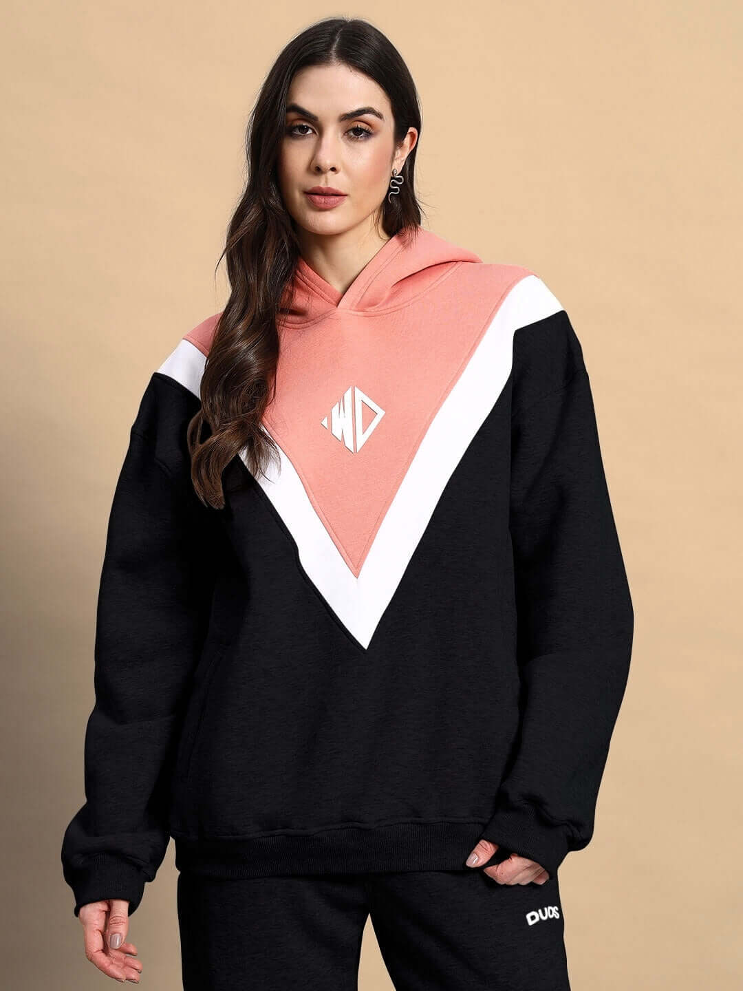 Woman wearing WOMEN POLAR COLORBLOCK HOODIE BLACK PEACH with black and peach colorblock design, premium fleece fabric, modern and cozy streetwear.