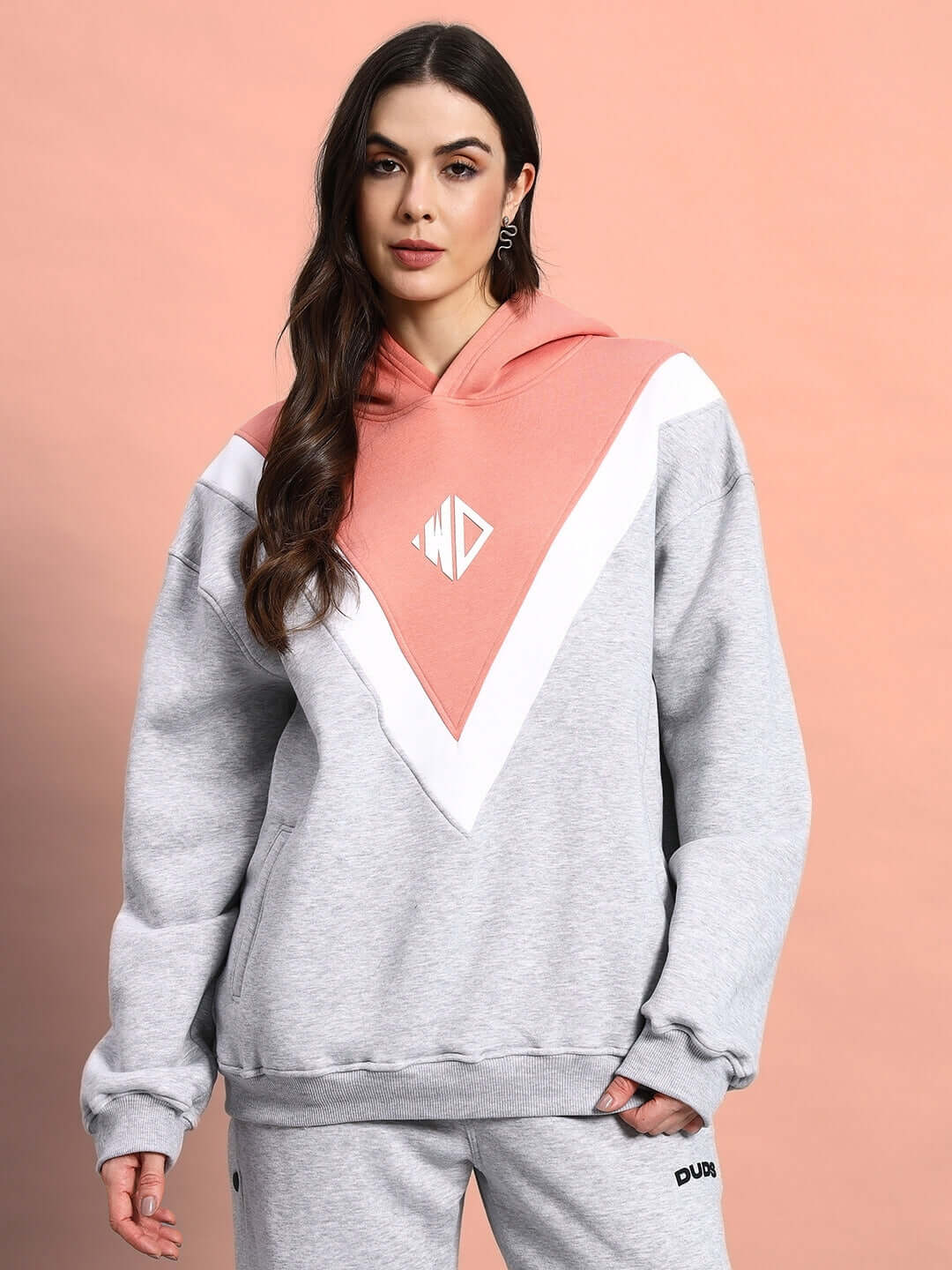 Woman wearing WOMEN POLAR COLORBLOCK HOODIE GREY PEACH with a stylish grey and peach colorblock design