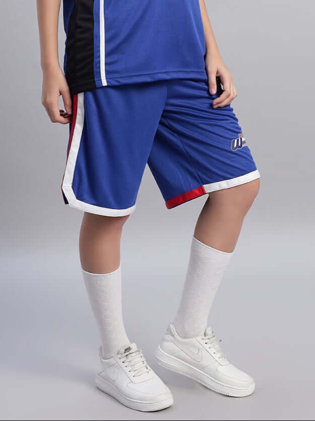 Woman wearing royal blue Portia regular fit shorts, with white and red trim, styled with white socks and sneakers.