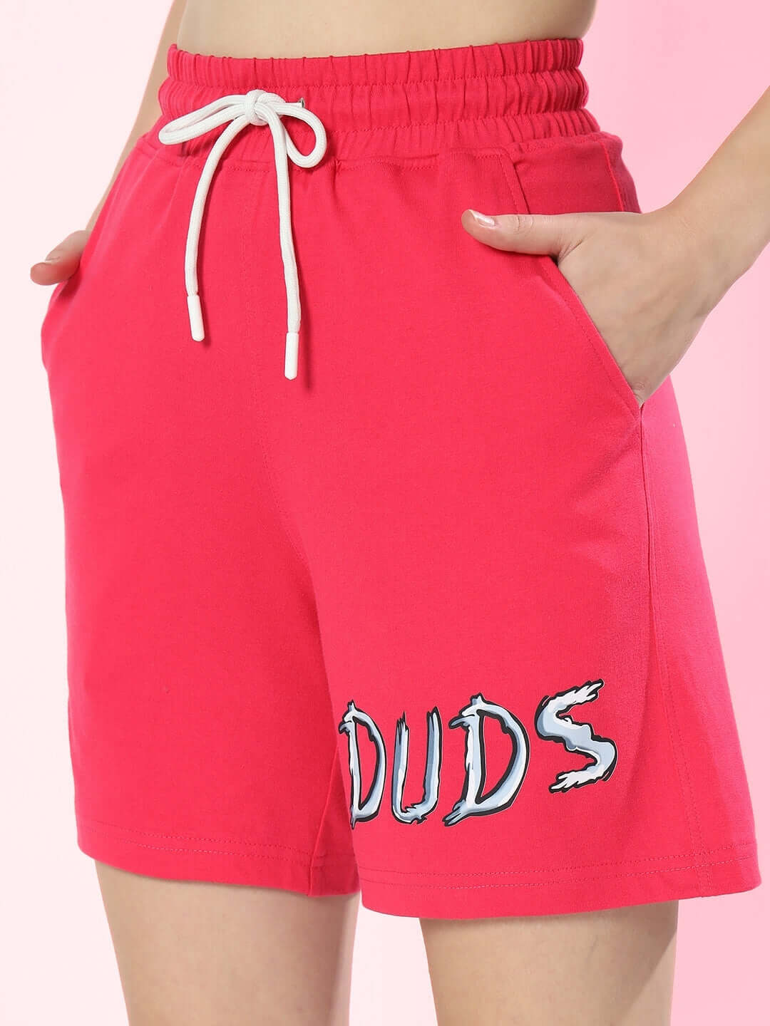 Women's pink shorts with elastic waistband and drawstring, featuring 'DUDS' print on the side.