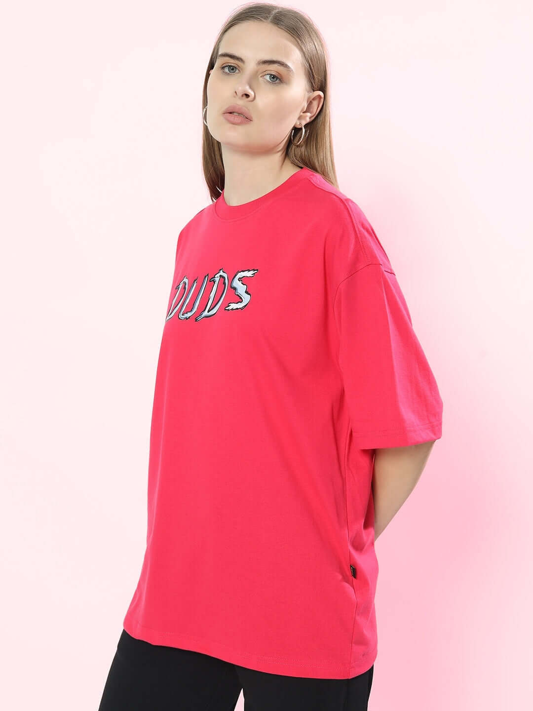 Woman wearing WOMEN POSITIVE RABBIT OVER-SIZED T-SHIRT PINK with bold graphic, showcasing casual streetwear style.