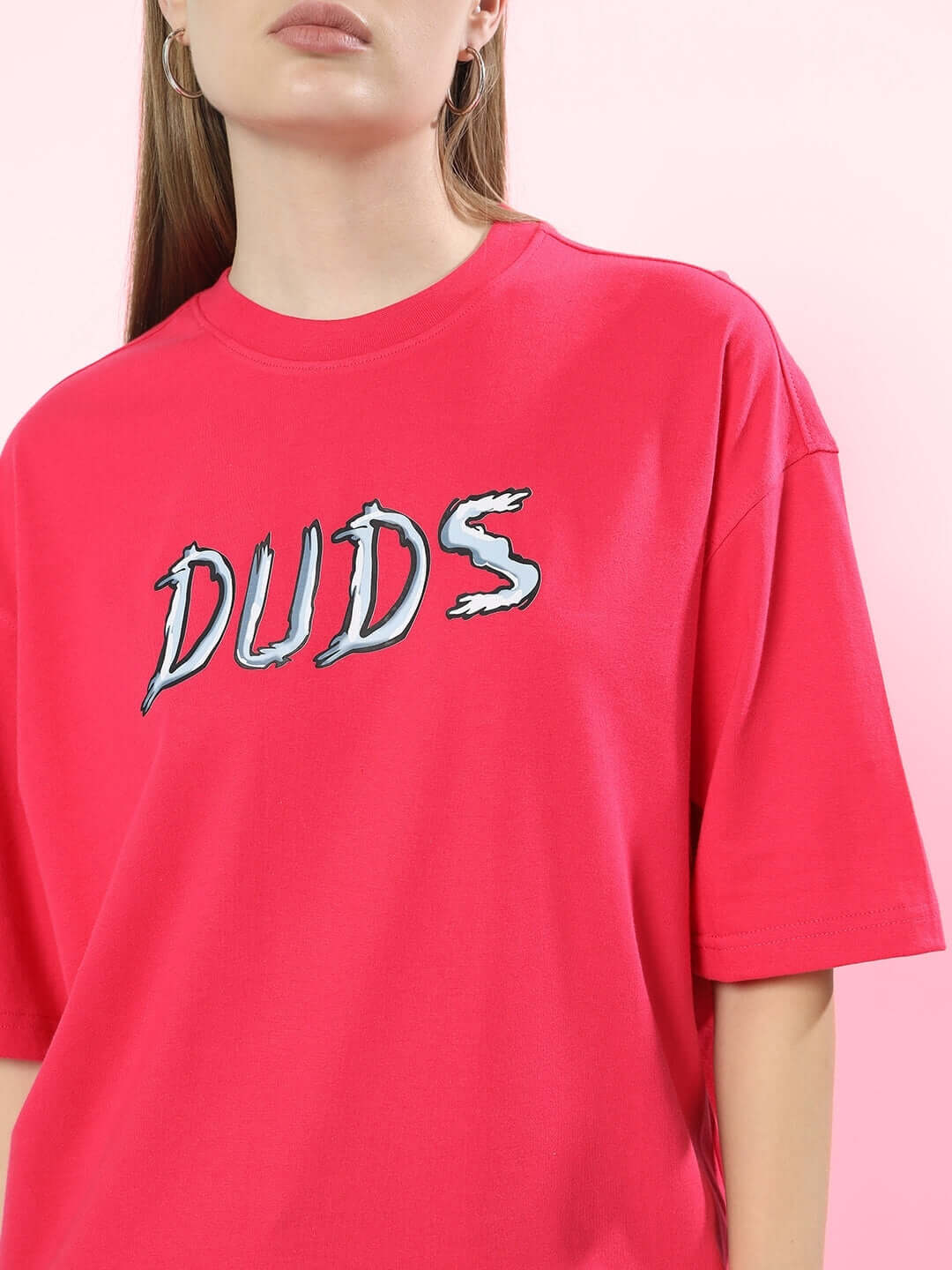 Model wearing Women Positive Rabbit Over-Sized T-Shirt Pink with 'DUDS' graphic design, casual streetwear fashion.