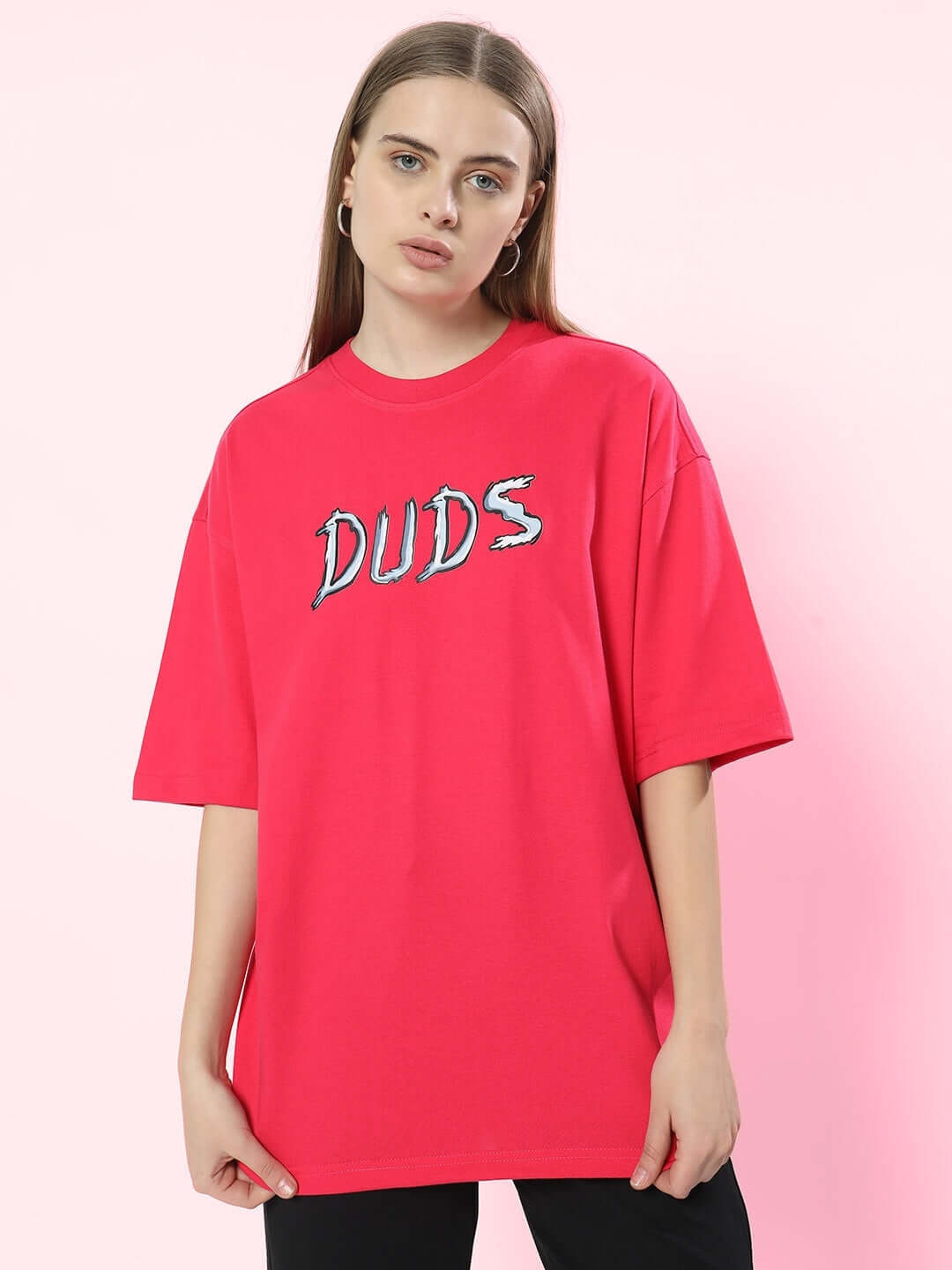 Model wearing pink oversized t-shirt with 'DUDS' text, made of 100% cotton, perfect for casual wear.