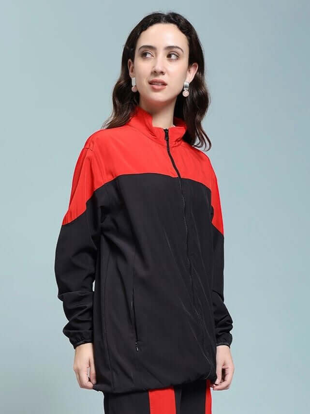 Woman wearing WOMEN POWER BLOCK RELAXED FIT JACKET BLACK RED, merging sporty style with bold red accents and sleek black base.