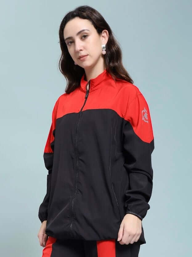 Woman wearing WOMEN POWER BLOCK RELAXED FIT JACKET BLACK RED with black base and red accents, showcasing sporty and stylish design.