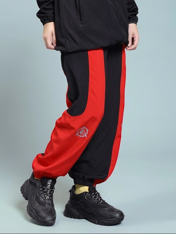 WOMEN'S POWER BLOCK RELAXED FIT JOGGER BLACK RED with black sneakers, showcasing relaxed style and bold design elements.