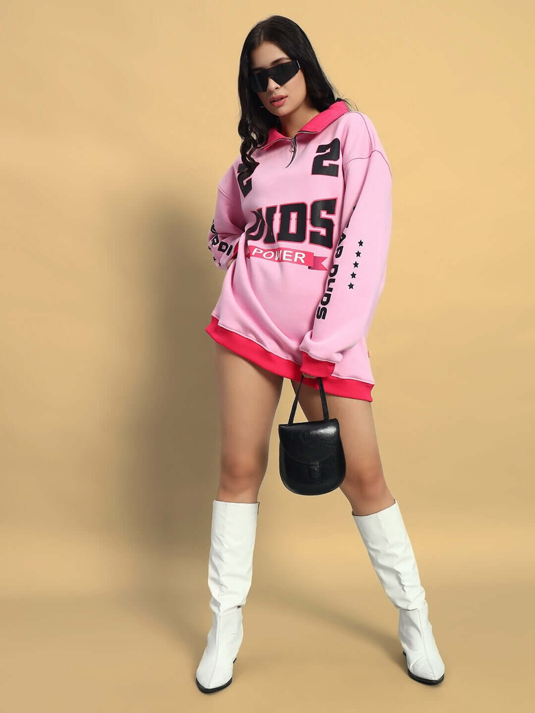 Model wearing WOMEN'S POWER22 SWEATSHIRT DRESS PINK with white boots and black bag, showcasing vibrant casual chic style.