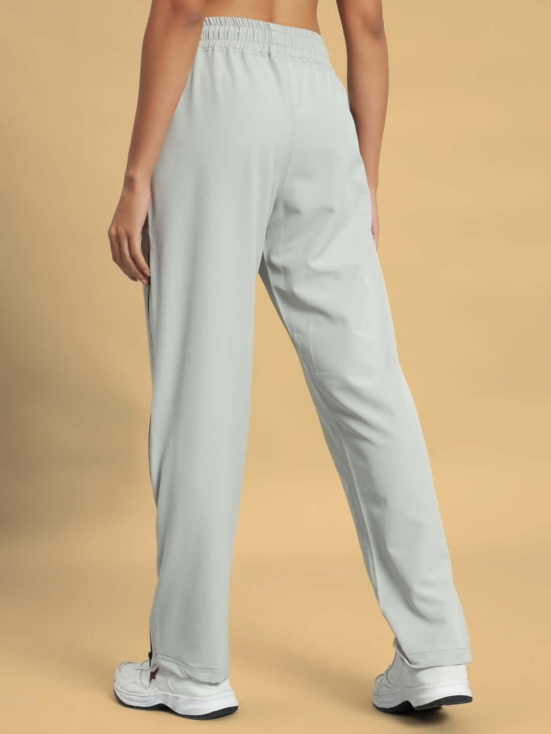 Back view of women's grey parachute cargo pants showcasing relaxed fit and elastic waistband.