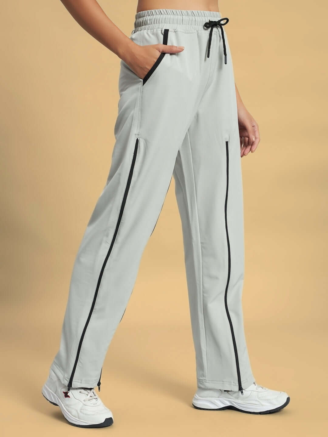 Women's grey parachute cargo pants with zippers, elastic waist, and drawstring for a custom fit, perfect for versatile styling.