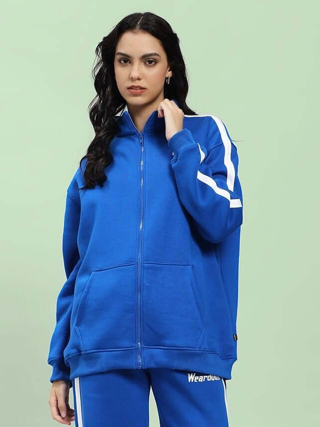 Woman wearing WOMEN RAPID STRIDE COTTON FLEECE JACKET ROYAL BLUE, showcasing its sporty chic design and vibrant color in a casual setting.