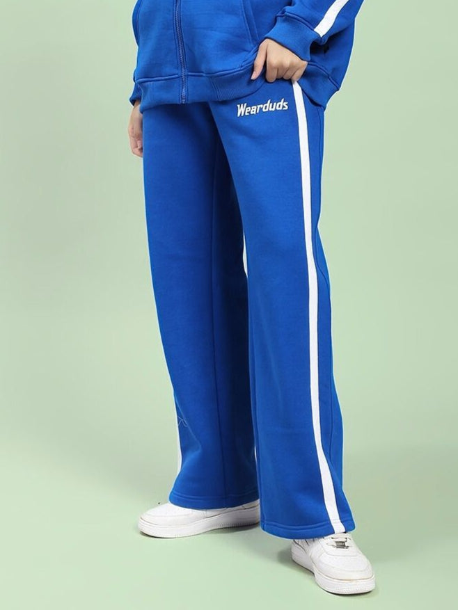 WOMEN'S RAPID STRIDE FLEECE JOGGER ROYAL BLUE athletic pants with side stripe, shown worn with matching top and white sneakers.