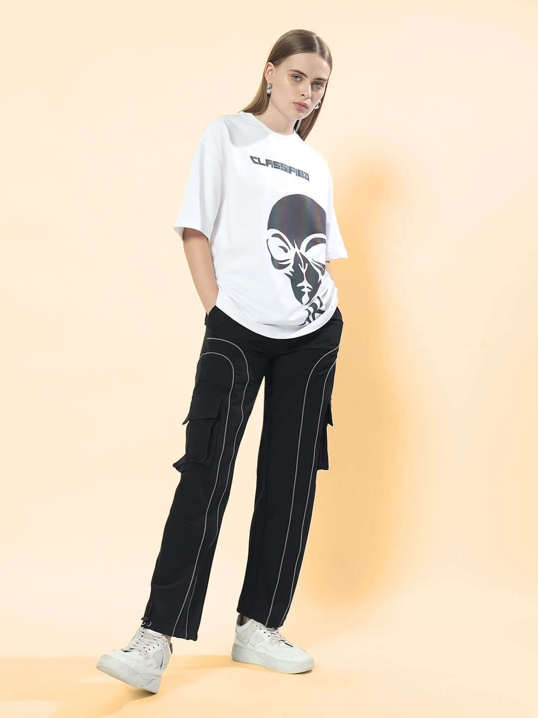 Model wearing black Women's Ray Reflector Parachute Cargo Pants with a graphic tee, showcasing casual streetwear style.